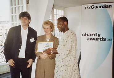 Alex Oma-Pius receiving the Charity Award from The Guardian